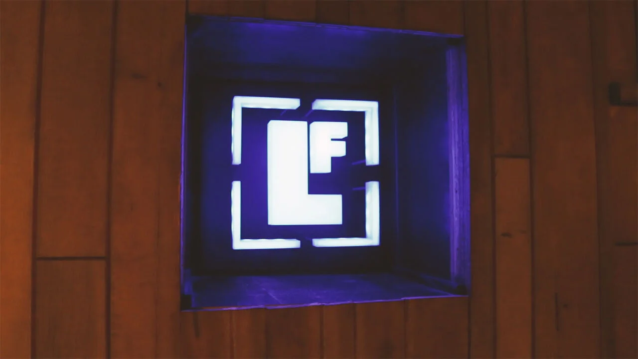 Custom LED-backlit logo sign built into a wood-paneled wall